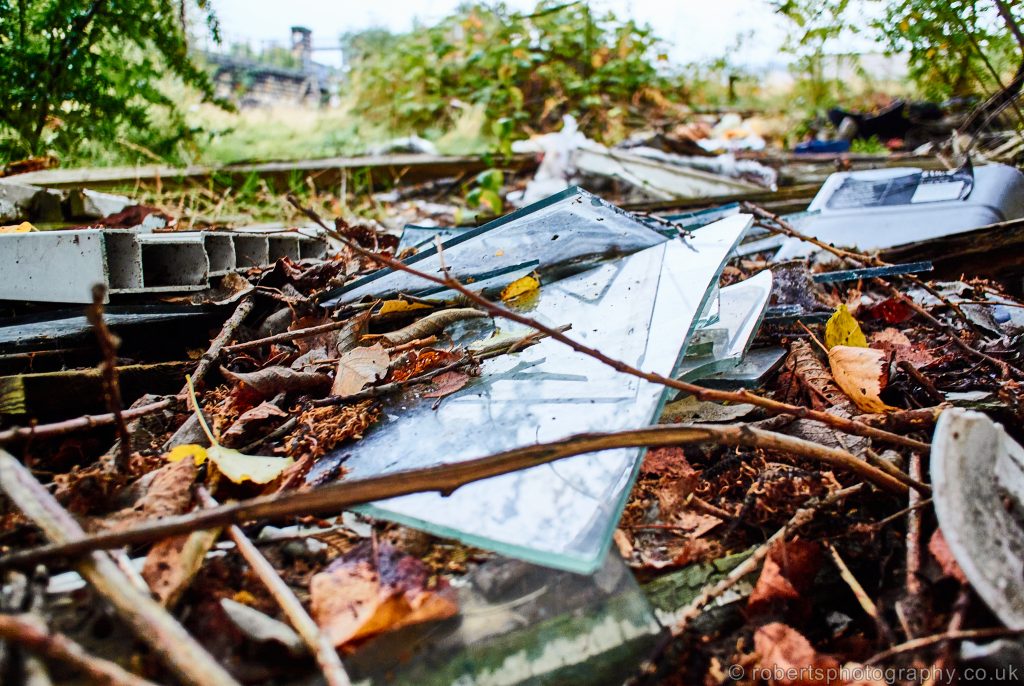 The dangers of fly tipping are highlighted with broken glass.