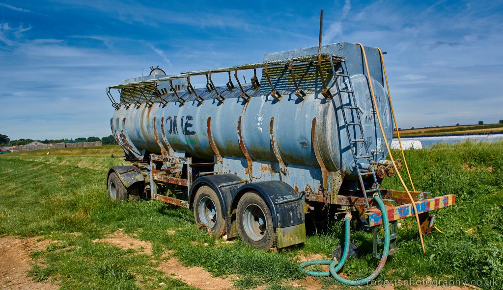 An old milk tanker on a farm, used as a water tank for irrigation.
