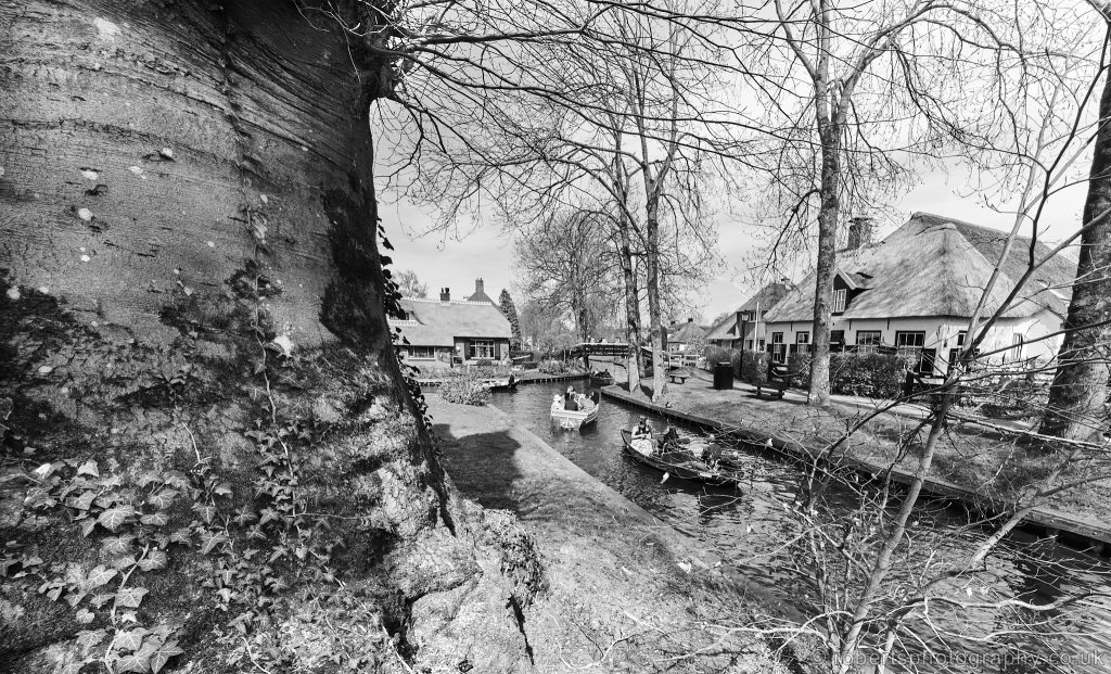 People in hire boats are pictured navigating the narrow canals of Giethoorn, the Netherlands.
